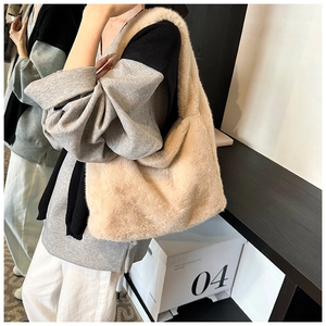 Gros plan détaillé sur la texture douce en peluche du sac cabas beige en fausse fourrure