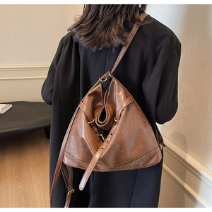 Detailed back view of a vintage brown PU leather backpack on a model in minimalist interior