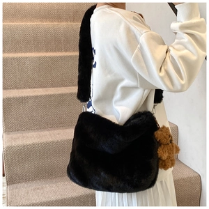 Détail du sac à bandoulière en peluche noire avec breloque ours et sangle douce