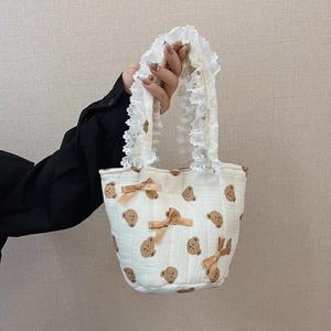 Elegante borsa trapuntata beige con motivi a orsetto e finiture in pizzo bianco sui manici