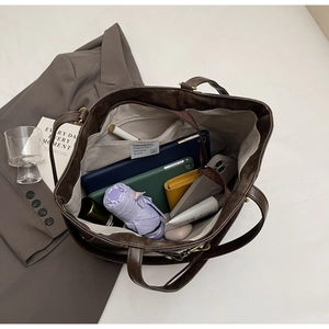 Top view of deep brown tote bag interior with organized multi-layer storage compartments