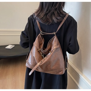 Rear view of brown PU leather hobo backpack with adjustable straps and metal buckles