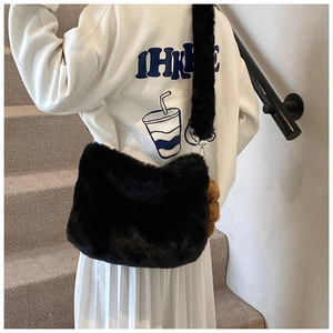 Détail de la texture d'un sac bandoulière en fausse fourrure noire avec ours en peluche