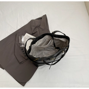 Top-down view of the black tote bag interior with a practical zipper pocket and fabric lining