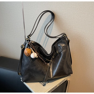 Black PU leather shoulder bag with baseball charms and decorative stitching detail