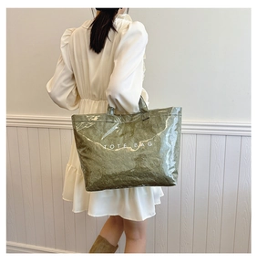 Detail view of moss green Dupont paper tote bag with white TOTE BAG text print