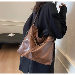 Close-up of vintage brown PU leather tote with bronze hardware and cross strap details