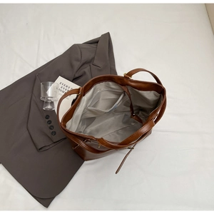 Top view of brown faux leather tote bag with gray lining and inner zipper pocket