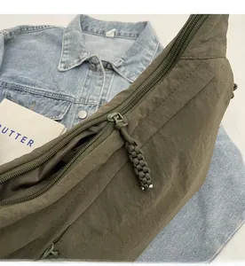 Detail of the army green crossbody bag showing durable nylon texture and woven rope zipper