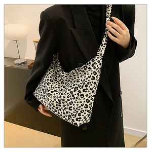 Detailed macro view of cream leopard print canvas tote bag with wide shoulder strap