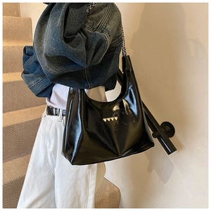 Borsa hobo in vernice nera con borchie a cuore dorate indossata dalla modella