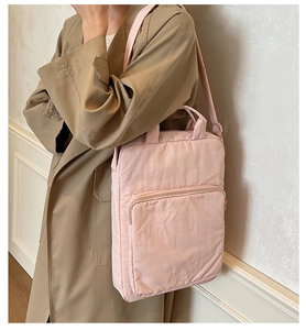 Detail der hellrosa gefalteten Nylon-Tasche getragen zu einem khakifarbenen Trenchcoat