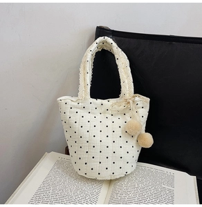 Détail du sac en coton matelassé à pois avec anse en dentelle et pompons doux