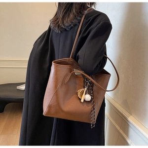 Gros plan sur sac cabas en similicuir marron avec breloques de baseball élégantes