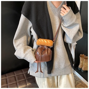 Close-up of brown PU leather bucket bag with creative bread plush charm and drawstring closure