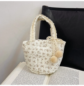 Vue détaillée du sac en coton matelassé avec imprimé floral et nœud en dentelle fine