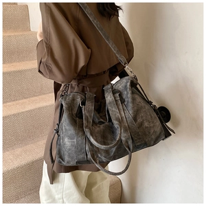 Détail du sac à bandoulière rétro gris foncé avec sangle réglable porté par un mannequin