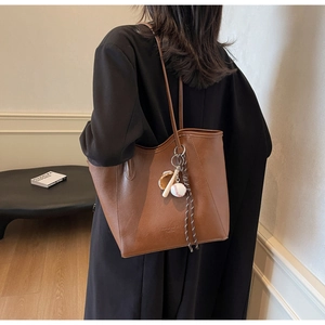 Détail du sac cabas en cuir PU marron avec un pendentif sur le thème du baseball