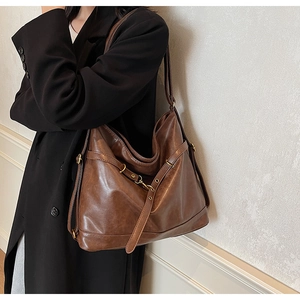 Detailed close-up of dark brown PU leather tote with vintage golden buckles and straps