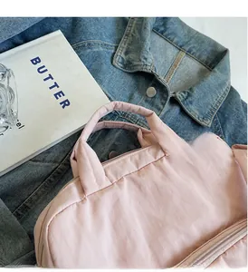 Nahaufnahme der rosa Nylon-Schultertasche mit robusten Griffen und leichter Stoffstruktur