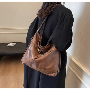 Brown vintage faux leather hobo bag worn by model, showcasing the large capacity and style