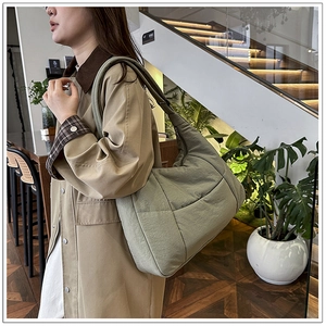 Detail of sage green quilted nylon hobo bag showing spacious interior and soft fabric texture
