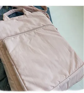 Detail der weichen rosa gesteppten Nylontasche und der glatten vorderen Reißverschlusstasche