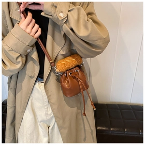 Detail of dark brown PU leather bucket bag with creative plush baguette accessory