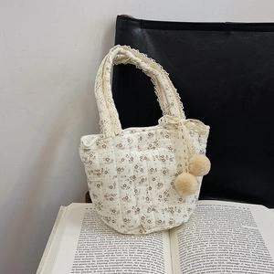 Petit sac à main en coton matelassé avec fleurs, anses en dentelle et pompons beiges