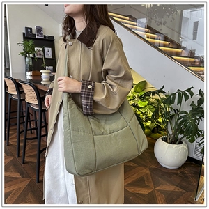 Detail of olive green quilted crossbody bag showing soft nylon texture and large capacity