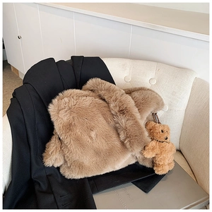 Sac à épaule en peluche marron avec breloque ours sur un costume noir élégant