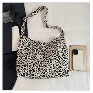 Detail of leopard print canvas tote bag with knot strap detail on a white fabric background