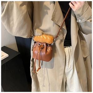 Detail of creative brown PU leather bucket bag featuring a unique plush baguette-shaped decor