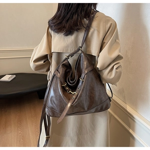 Detail of vintage brown PU leather shoulder bag with decorative straps and metal buckles