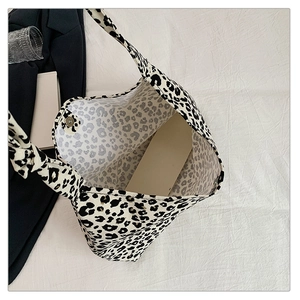 Detailed view of the leopard print canvas tote bag featuring a metallic magnetic closure