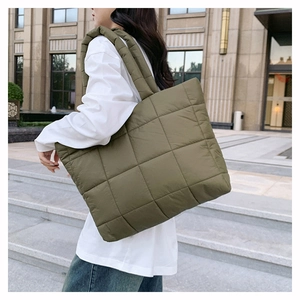 Détail du sac cabas matelassé en nylon vert olive avec larges bandoulières en ville