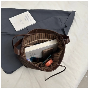 Interior view of large brown tote bag with striped lining and multiple compartments
