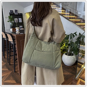 Detail of sage green quilted nylon hobo bag with soft texture and refined stitching