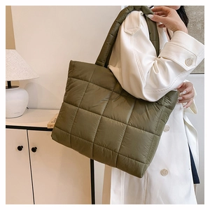 Détail d'un sac cabas en nylon matelassé vert armée avec texture bouffante sur modèle