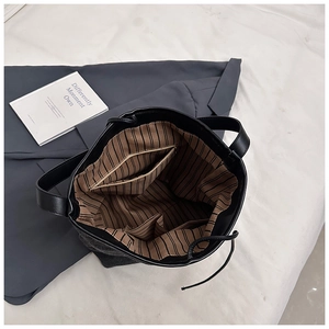 Detail of PU tote bag interior featuring dark gray fabric, black leather trim and card slots