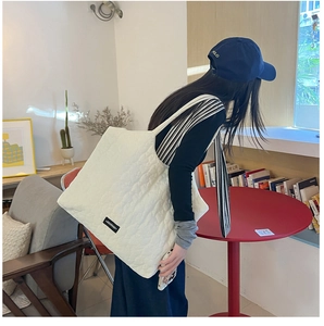 Chic cream quilted tote bag styled in a cafe setting for a modern minimalist autumn look