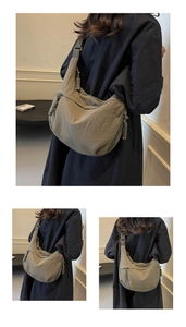 Macro detail of the dark green nylon crescent bag showing textured fabric and durable zipper