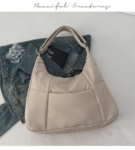 Detailed top view of a large beige crossbody dumpling bag with soft padded nylon texture