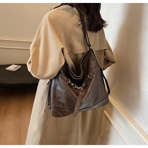 Detailed view of deep brown vintage PU leather hobo bag with metallic buckles and eyelets