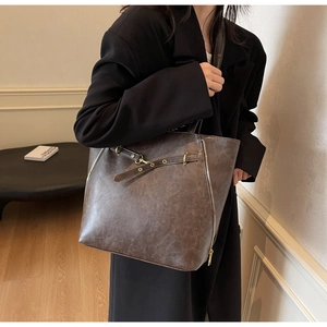 Dettaglio della borsa tote vintage marrone scuro con fibbie e cerniere decorative