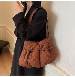 Detail of brown quilted puffy tote bag with drawstring pockets and nylon texture