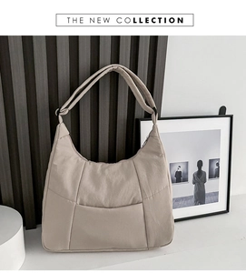 Detail view of beige nylon crossbody bag featuring stylish stitching and wide shoulder strap