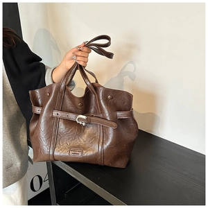 Dettaglio della borsa tote in pelle PU con trama litchi, fibbia in metallo e logo