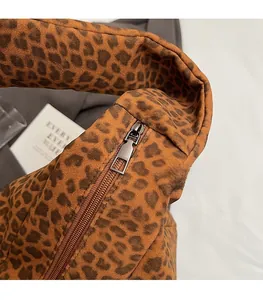 Détail de la fermeture éclair métallique sur sac à bandoulière en daim imprimé léopard