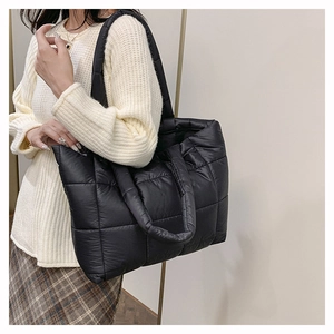 Détail du sac fourre-tout en nylon noir matelassé avec texture bouffante et sangle
